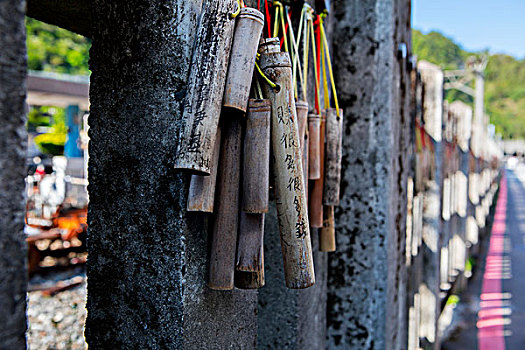 台湾著名的观光景点,瑞芳猴硐的猫村,铁道旁的石头栅栏,是一个祝福墙,上面吊挂着希望,留言,祈祷,的竹筒