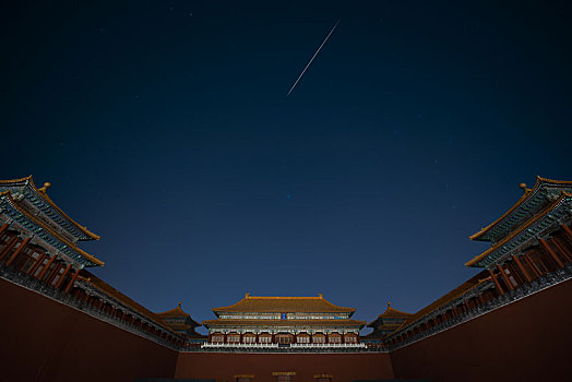 晴朗的夜晚北京故宫午门上空划过一颗流星