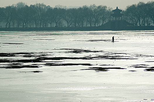 冬季公园内结冰的湖面上走的人