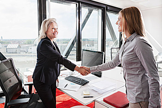 两个女人,握手,办公室