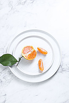 放在白色盘子里的桔子橙子橘子