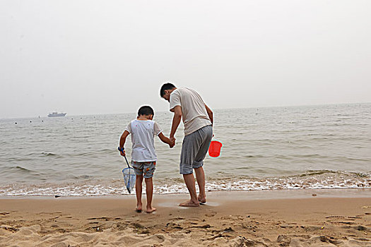 夏日大海边游玩的父子