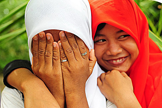indonesia,sumatra,banda,aceh,two,shy,girl,friends,with,veil,and,hiding,in,front,of,camera