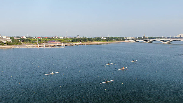 山东省日照市,运动员训练泛舟湖面,蓝天下的水上公园景色优美