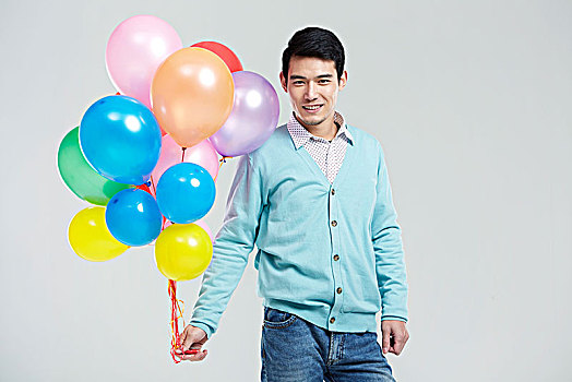 拿彩色气球的亚洲男青年