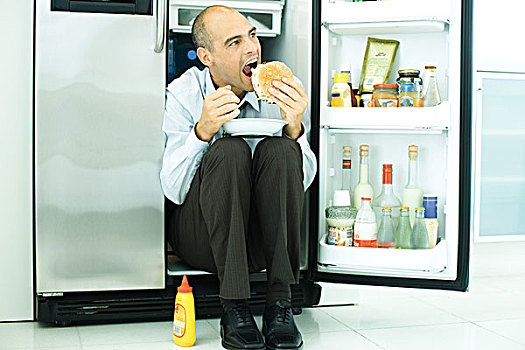 男人,坐,正面,打开,冰箱,吃,汉堡包