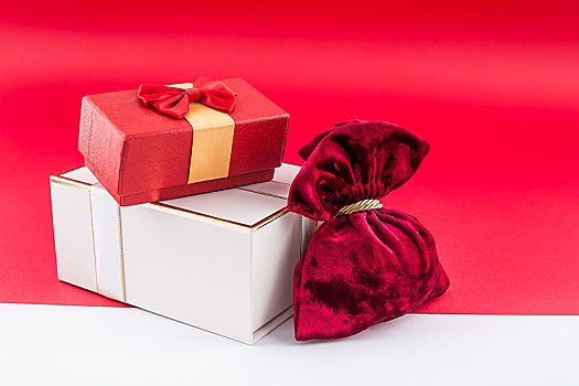 红色和粉色的节日礼盒放在红白相间的背景纸上