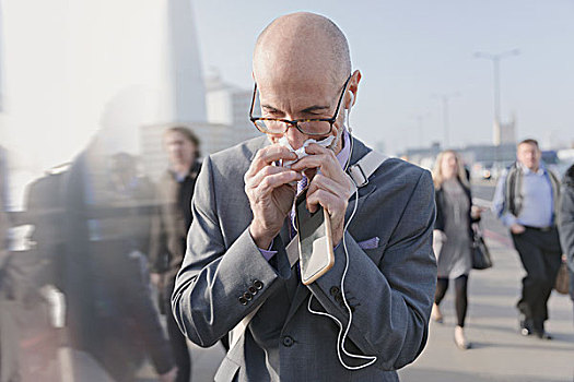商务人士,擤鼻涕,纸巾,拿着,手机,耳机,城市,步行桥