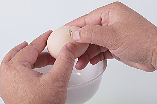 两只手将打开的鸡蛋放在碗里