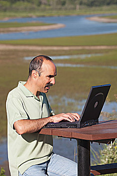 男人,打字,笔记本电脑,坐,野餐桌,背景,卡尔加里,艾伯塔省,加拿大
