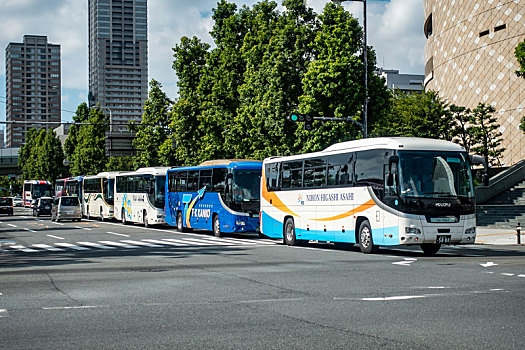 众多的旅游大巴车停靠在日本大阪城附近的路边