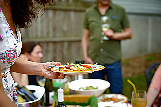 女人,花园派对,拿着,盘子,食物,腰部