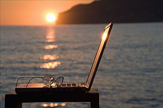 笔记本电脑,老花镜,日落