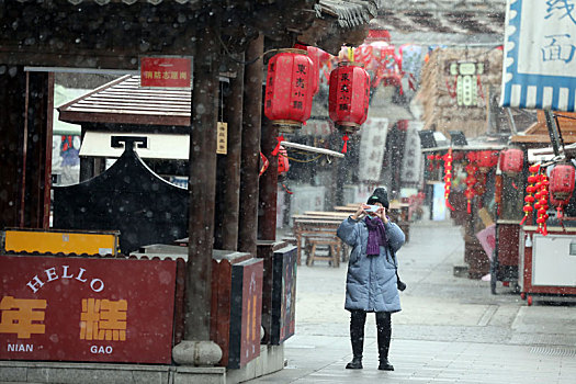 山东省日照市,小年迎来初雪,市民雪中漫步东夷小镇