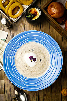 木桌子上的一份泡沫丰富的奶油蘑菇汤