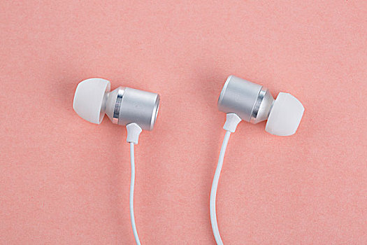 银色的耳机和粉色的背景