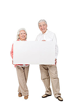 一对老年夫妇拿着白板