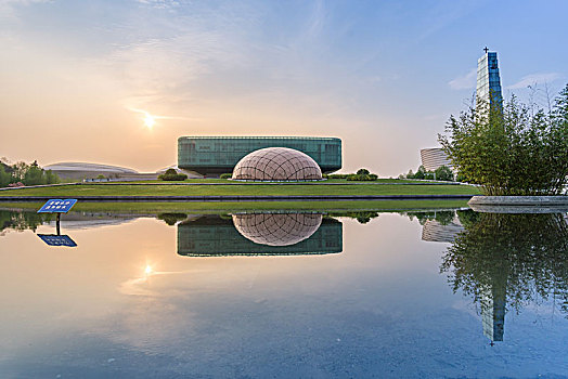 落日下的南京地标建筑池塘倒影