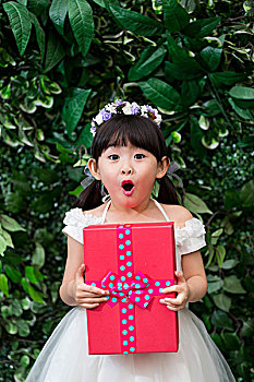 快乐的小花童抱着礼物盒