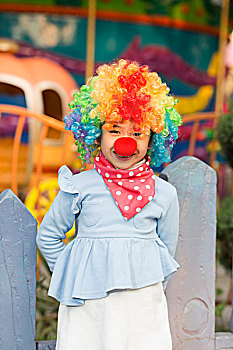 牵气球的小女孩在游乐园扮小丑