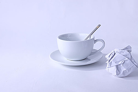 一个空的咖啡杯和一团废纸