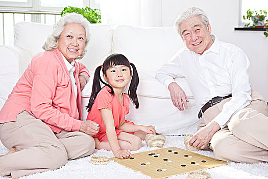 一对老年夫妇和孙女下围棋