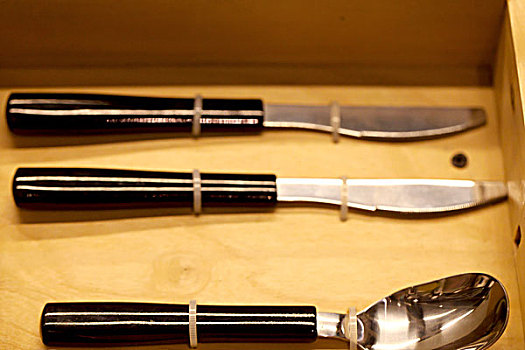 三把整齐的金属餐具勺子和刀