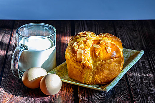 摆放在木质桌面上的早餐,面包,鸡蛋和一杯牛奶