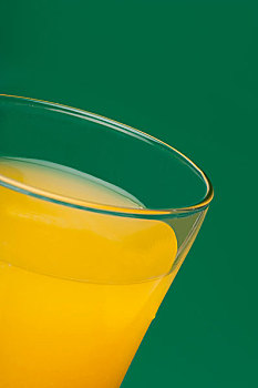 一杯橙汁在绿色背景上