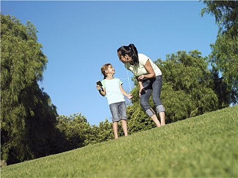 母女,6-8岁,站立,草,公园,女孩,拿着,mp3播放器,贴地拍摄,倾斜