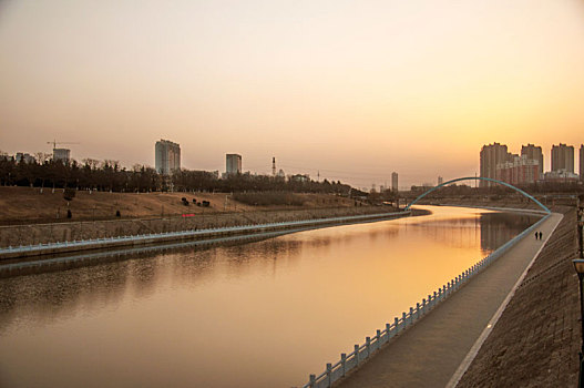 清晨暖色光线中的城市河流
