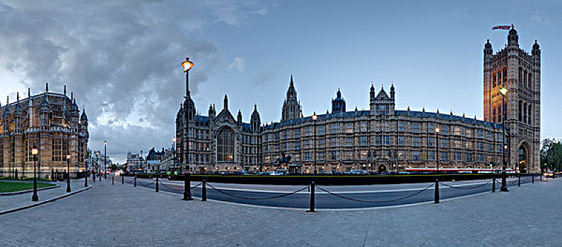 蓝天白云下坐落在绿色草地上的具有欧洲风格的英国伦敦塔和一栋古典建筑
