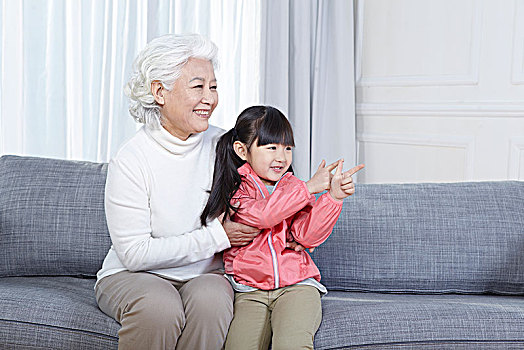奶奶抱著孫女坐在沙發上