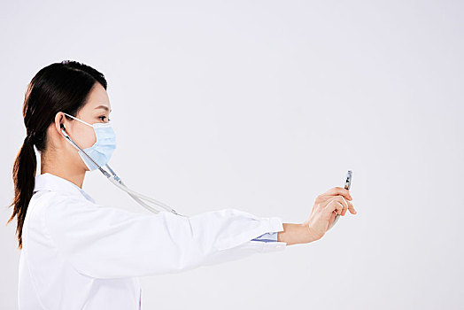 一位戴口罩的女醫生使用聽診器