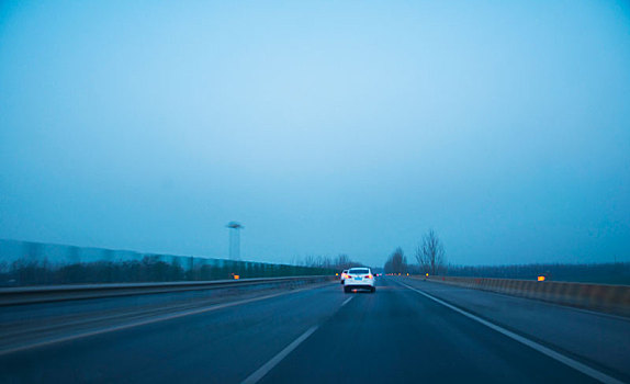 昏暗环境中行驶在高速公路的汽车