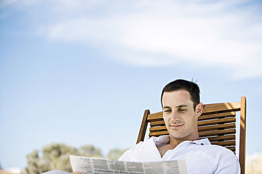 男青年,坐,折叠躺椅,读报