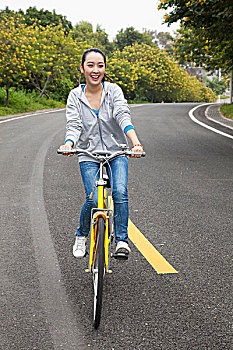 一个年轻女大学生在校园里骑车