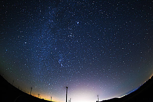 中国草原上璀璨星空下的风车