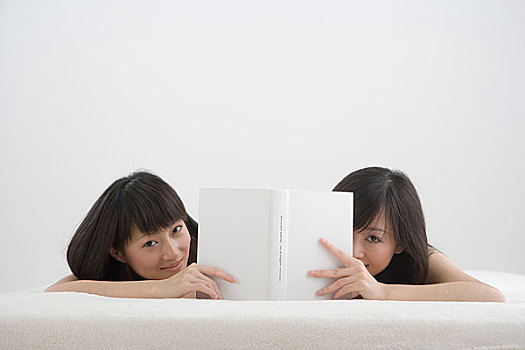 一起趴着看书的两个女人