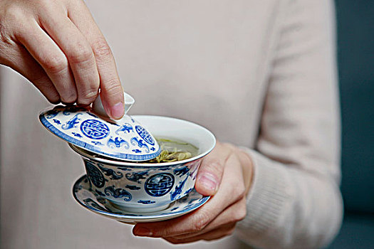 一个女人在喝盖碗茶