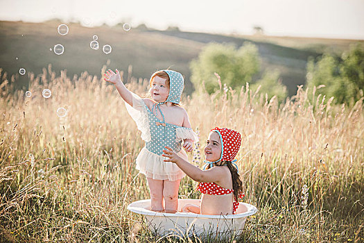 两个女孩,地点,玩,塑料容器罐,水