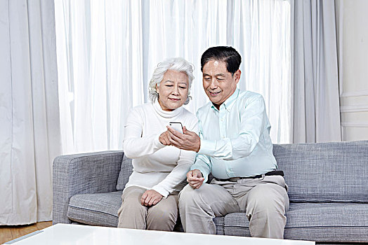 老年夫妇在家中看手机