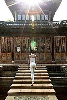 站在古建筑前做瑜伽的女士