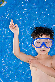 穿着游泳衣戴着潜水镜对着镜头玩耍的儿童