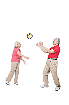一对老年夫妇拿着排球