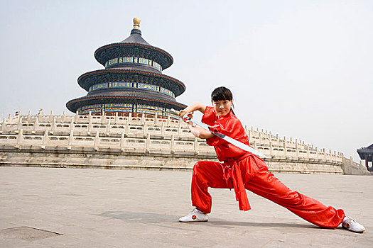 中国武术--一名女武术运动员在天坛祈年殿前练刀法