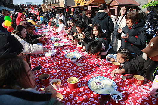 小镇摆下百米长桌宴,市民游客新年吃饺子交好运