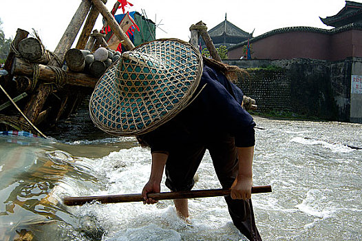 中国非物质文化遗产-都江堰放水节,堰工正在清理放水缺口附件的木头,疏浅河道