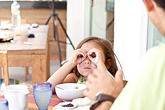 父亲,女儿,坐,早餐桌,制作,双筒望远镜,手指