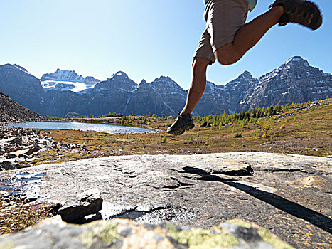 加拿大,艾伯塔省,班芙国家公园,远足者,跳跃,石头,石板,草地